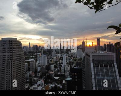 Vista aerea dello skyline di Bangkok durante il tramonto da un tetto in una giornata nuvolosa Foto Stock