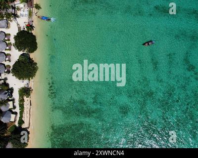 Vista dall'alto della spiaggia di Ko Ngai con sabbia bianca, acqua turchese e barche a coda lunga Foto Stock