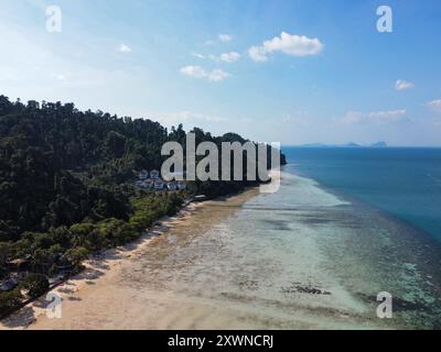 Vista aerea di Ko Ngai con la bassa marea in una giornata di sole, la vista include resort di lusso sulla collina, la barriera corallina e l'acqua turchese Foto Stock