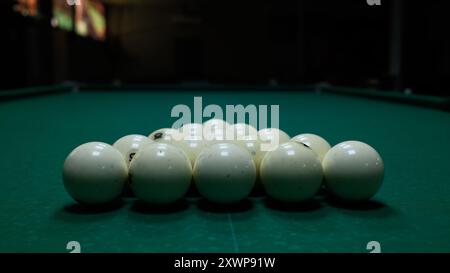 Palle da biliardo disposte a triangolo su un tavolo in feltro verde. Disposizione di biliardo o biliardo, sport e svago. Foto Stock