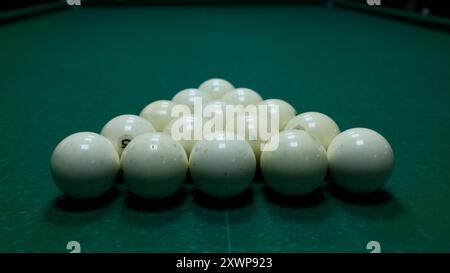 Palle da biliardo disposte a triangolo su un tavolo in feltro verde. Disposizione di biliardo o biliardo, sport e svago. Foto Stock