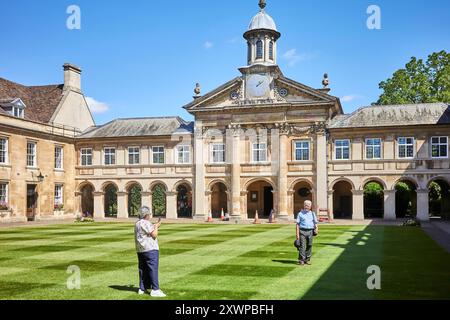 I visitatori scattano una foto nel cortile anteriore dell'Emmanuel College, Università di Cambridge, Inghilterra. Foto Stock