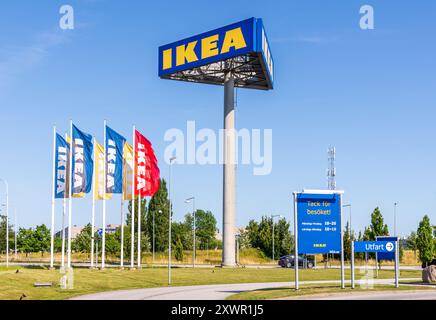 Un alto cartellone su tre lati mostra il cartello IKEA all'ingresso del negozio IKEA di Malmö, Svezia, accanto ai banner IKEA. Foto Stock