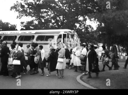 Un carico di autobus di afroamericani August sbarca gli autobus turistici al Cimitero Nazionale di Arlington per visitare la tomba del presidente John F. Kennedy nel 1964. Foto Stock