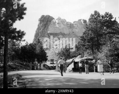 Le persone camminano attraverso il parcheggio a Mt. Rushmore National Monument, ca. 1946. Foto Stock