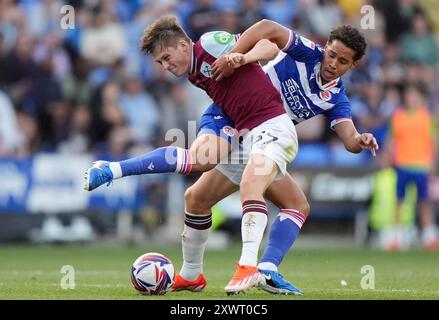 Oliver Scarles (davanti) del West Ham United U21 è sfidato da Ben Elliott (dietro) di Reading durante il Bristol Street Motors Trophy, Southern Group H Match al Select Car leasing Stadium, Reading. Data foto: Martedì 20 agosto 2024. Foto Stock