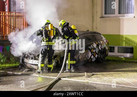 240820PKWBrand News ID: EN 2024-08-20 Erneut PKW in Flammen Feuerwehreinsatz an Kindergarten Zwönitz. In der Nacht zum Dienstag Hat in der Stadt erneut ein PKW gebrannt. Gegen 22:50 Uhr wurden Anwohner auf einen brennenden Opel an einem Kindergarten in der Lessingstraße aufmerksam und verständigten die Feuerwehr. Wie Lars Seitenglanz, Einsatzleiter der Stadtfeuerwehr Zwönitz berichtet, stand der Wagen bei Ankunft der Kameraden im Motorbereich a Vollbrand. Da der brennende PKW an einem Gebäude geparkt War und somit eine Ausbreitungsgefahr bestand, wurden neben der Feuerwehr Zwönitz, auch die F. Foto Stock