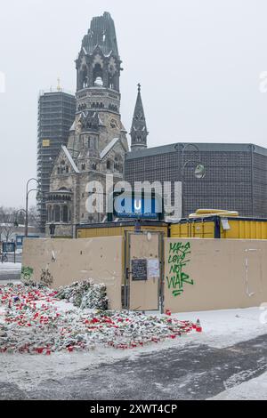 Un solenne luogo commemorativo di fronte alla chiesa commemorativa del Kaiser Wilhelm a Berlino, con fiori e candele che commemorano le vittime dell'attacco al mercatino di Natale del dicembre 2016. Appello simbolico alla pace in mezzo a una tragedia. Foto Stock