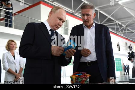 Germenchik, Russia. 20 agosto 2024. Il presidente russo Vladimir Putin, a sinistra, osserva i prodotti a base di frutta secca durante un tour dell’impresa agricola Agro-07 accompagnato dal direttore della società Alim Geduev, a destra, 20 agosto 2024 a Germenchik, Kabardino-Balkaria, Russia. Crediti: Vyacheslav Prokofyev/piscina del Cremlino/Alamy Live News Foto Stock