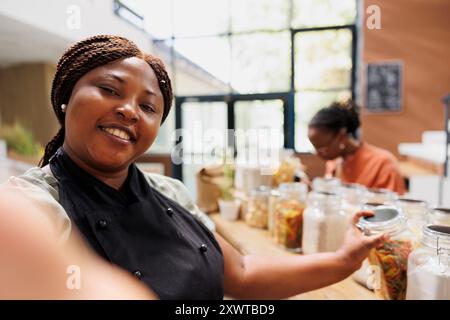 La blogger femminile crea contenuti eco-compatibili promuovendo lo shopping sostenibile e senza plastica e una vita sana. Produttore che filma con smartphone, mostrando suggerimenti alla moda per uno stile di vita a basse emissioni di carbonio. Foto Stock