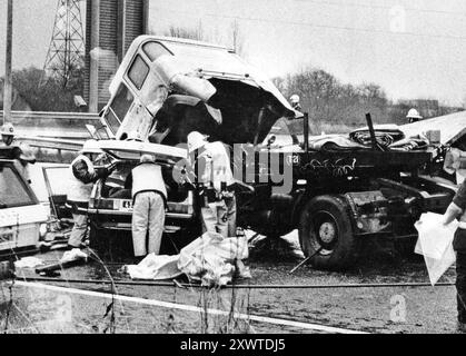 I VIGILI DEL FUOCO SI BATTONO PER LIBERARE LE PERSONE DAL RELITTO DOPO UNA COLLISIONE TRA UN CAMION ND UN'AUTO SULLA M27 VICINO A SOUTHAMPTON, CINQUE PERSONE SONO RIMASTE UCCISE.PIC MIKE WALKER 1980'S PIC MIKE WALKER 1980'S 1980'S Foto Stock