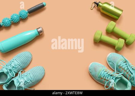 Telaio realizzato con sneakers e diverse attrezzature sportive su sfondo beige Foto Stock