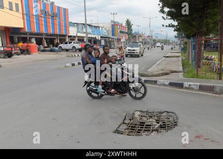 Wer in Wamena von der Hauptstraße in diese Seitenstraße abbiegt, muss aufpassen, keinen Unfall zu bauen. Unter dem Asphalt verläuft ein Abwasserkanal und die Teerdecke ist an einer stelle durchbrochen. DAS gleiche gilt für den Gehweg, wo einzelne Betonplatten verschoben sind. *** Chiunque chiuda la strada principale in questa strada laterale a Wamena deve fare attenzione a non causare incidenti Una fogna corre sotto l'asfalto e la superficie del catrame è rotta in un posto lo stesso vale per il marciapiede, dove le singole lastre di cemento si sono spostate Foto Stock