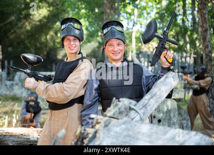 Due sorridenti paintball giocatori in piena attrezzatura divertirsi prima del gioco Foto Stock