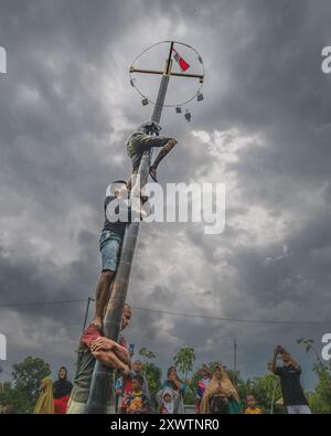 Balikpapan, Indonesia - 18 agosto 2024. Il Panjat Pinang o competizione di arrampicata sulle palme è una tradizione indonesiana popolare, spesso tenuta come competizione Foto Stock