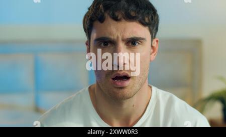 Primo piano faccia giovane europeo caucasico disgusto malinteso rifiuto strizzacervescente reazione confusa disprezzo espressione ritratto Foto Stock