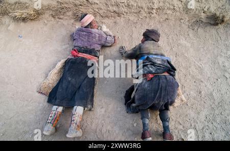 Pellegrini tibetani che si prostrano mentre si muovono lentamente intorno alla monarchia Labrang a Xiahe, Gansu, Cina. Foto Stock