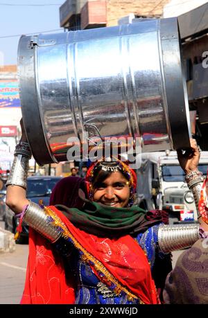 Una bella Rajasthani torna a casa con un barile sulla testa. Foto scattata a Bikaner, Rajasthan, India. Foto Stock