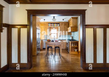 Cucina ristrutturata che si adatta bene alla casa originale, vista dall'ingresso con splendide opere in legno Foto Stock