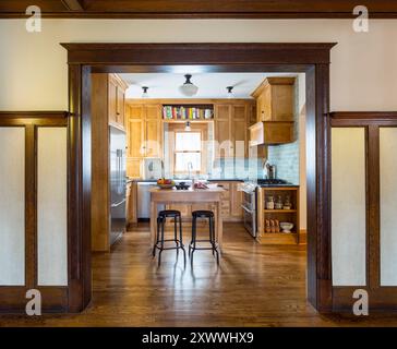 Cucina ristrutturata che si adatta bene alla casa originale, vista dall'ingresso con splendide opere in legno Foto Stock