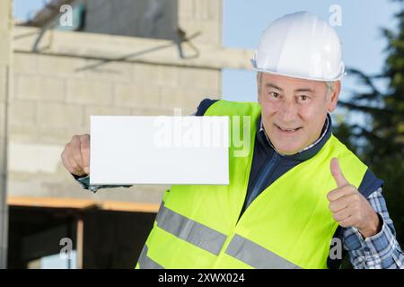 costruttore di uomini anziani che mostra una lavagna vuota Foto Stock