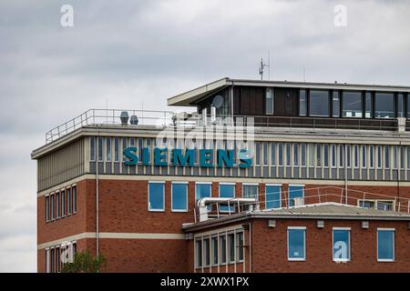 Unternehmen in mehrstöckiges Bürogebäude Ein Nürnberg mit Siemens-Logo auf der Fassade. DAS Gebäude Hat eine Mischung aus roten Ziegeln und großen Fenstern, die durch graue Betonpfeiler getrennt sind. Nürnberg Bayern Deutschland *** azienda di Norimberga edificio per uffici a più piani con il logo Siemens sulla facciata l'edificio presenta un mix di mattoni rossi e grandi finestre separate da colonne grigie in cemento Norimberga Baviera Germania 20240820-6V2A6934 Foto Stock