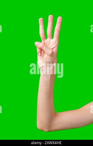 Primo piano della mano di una persona facendo il gesto numero tre contro uno schermo verde Foto Stock