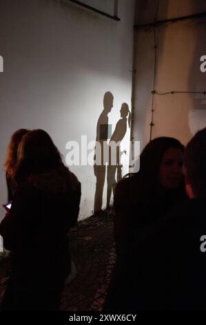 Una scena romantica in cui l'ombra di una coppia è gettata su un muro, simboleggiando emozioni e connessioni nascoste. Questa immagine di Passau, Bayern nel 2011 cattura il contrasto tra luce e buio, intimità e mistero. Foto Stock