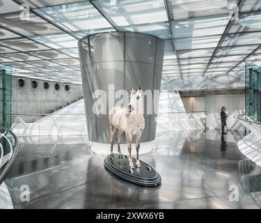 Mostra moderna con una scultura a cavallo che simboleggia una potenza a cavallo nel Mercedes Benz Museum di Stoccarda, Germania. Foto Stock