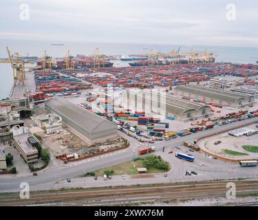 Ripresa aerea del vivace porto di Barcellona, Spagna, catturata nel 2005. La scena presenta numerosi container, gru, magazzini e navi, che mostrano le operazioni logistiche attive del porto in riva al mare. Foto Stock