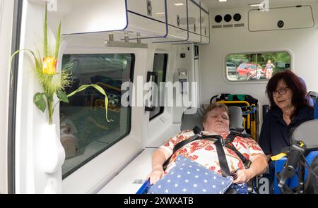 Oberstdorf, Germania. 20 agosto 2024. Anita Sräga (r) dell'Arbeiter-Samariter-Bund (ASB) parla con Kerstin Lindemann, che è disteso su una barella in un'ambulanza. Con il motto "osate fare gli ultimi desideri”, l'ASB trasporta i pazienti che non sono più in terapia in luoghi speciali per soddisfare i loro ultimi desideri e rendere possibili esperienze speciali. Crediti: Stefan Puchner/dpa/Alamy Live News Foto Stock