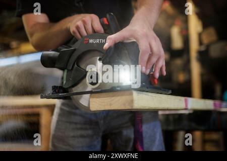 Berlino, Germania. 14 agosto 2024. Un uomo taglia il legno con una sega circolare. Berlino, 14 agosto 2024. Credito: dpa/Alamy Live News Foto Stock