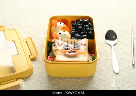 Pranzo al sacco con spuntini, cucchiaio e bacchetta su un tavolo di colore beige Foto Stock