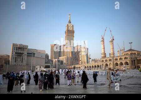 Mecca, Arabia Saudita - 6 giugno 2024: Pellegrini Hajj e Umrah da tutto il mondo che camminano vicino a Masjidil Haram, grande Moschea della Mecca, con un orologio da Foto Stock