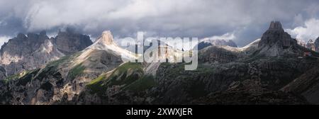 Ampio paesaggio alpino panoramico nelle Dolomiti, Italia, con cime rocciose, nuvole spettacolari e luce soffusa sulle Alpi italiane Foto Stock
