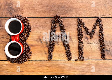 Inizia la giornata con un caffè fresco. Vista dall'alto del numero e delle lettere fatte con chicchi di caffè stesi sulla scrivania di legno Foto Stock