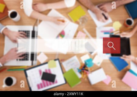 Alla ricerca di qualcosa di creativo. Vista dall'alto immagine ravvicinata di persone che lavorano insieme mentre si siedono alla scrivania di legno Foto Stock