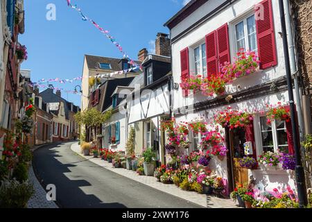 Fiori luminosi fuori dalle vecchie case tradizionali in Rue des Moulins, St Valery sur somme, somme, Piccardia, Francia Foto Stock