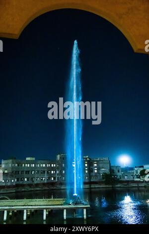 fontana con un lungo getto d'acqua di notte Foto Stock