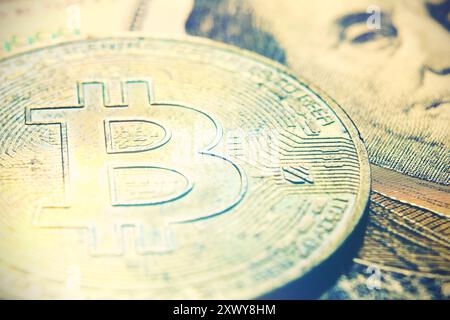 Cambio in dollari Bitcoin. Monete bitcoin d'oro (BTC) sullo sfondo di banconote banconota da 100 dollari con il presidente Benjamin Franklin. Denaro virtuale e. Foto Stock