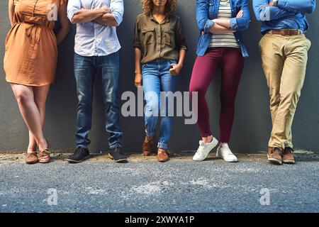 Gruppi, membri e persone d'affari sul muro per reclutamento, hr o assunzione di un concorso presso una startup creativa. Scarpe, colloquio di lavoro o attesa in fila all'aperto Foto Stock