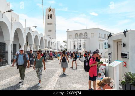 Santorini, Grecia - 8 ottobre 2019: I turisti esplorano le affascinanti strade fiancheggiate dall'iconica architettura bianca sotto un cielo azzurro. Foto Stock