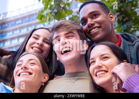 Gruppo di amici multietnici felici e sorridenti che guardano la fotocamera. Foto Stock