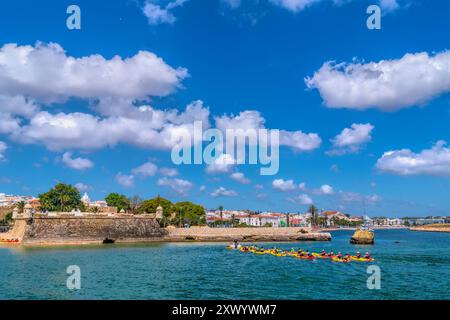 Gente portoghese sul lungomare di Lagos e sport acquatici in canoa kayak nella splendida città dell'Algarve Foto Stock