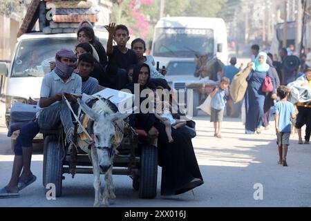 I palestinesi, che trasportano i loro averi, stanno per migrare verso aree più sicure, seguendo l'avvertimento dell'esercito israeliano per l'evacuazione i palestinesi, che trasportano i loro averi, stanno per migrare verso aree più sicure, seguendo l'avvertimento dell'esercito israeliano per l'evacuazione delle aree di Abu Areef e al-Mazra a Deir al-Balah, Gaza, il 21 agosto 2024. Foto di Naaman Omar apaimages Dair EL-Balah Striscia di Gaza territorio palestinese 210824 Dair EL-Balah NAA 00108 Copyright: XapaimagesxNaamanxOmarxxxapaimagesx Foto Stock