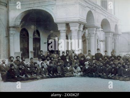 Foto d'epoca dei rappresentanti del primo Parlamento iraniano. Teheran, 1906 questa fotografia mostra i rappresentanti delle prime Majles iraniane (parlamento) di fronte all'accademia militare, che servì come primo edificio del parlamento. Tra il 1870 e l'inizio del XX secolo, le principali figure politiche iraniane conclusero che l'unico modo per salvare il paese dalla corruzione del governo e dalla manipolazione straniera era era creare un codice scritto di leggi, un atteggiamento che gettò le basi per la rivoluzione costituzionale iraniana del 1905-7. Il movimento per una costituzione diede frutti durante il regno di Muz Foto Stock