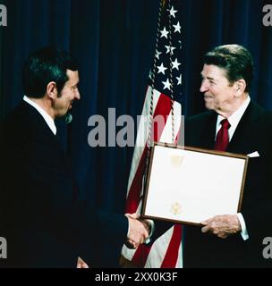 Il presidente Ronald Reagan stringe la mano a Andrew J. Stofan. Andrew John Stofan (26 gennaio 1935) è un ingegnere statunitense. Ha lavorato per la National Aeronautics and Space Administration (NASA). Negli anni '1960 giocò un ruolo importante nello sviluppo del razzo Centaur nello stadio superiore. Negli anni '1970 gestì gli uffici di progetto Atlas-Centaur e Titan-Centaur, e supervisionò il lancio delle sonde Pioneer 10 e Pioneer 11 su Giove e Saturno, le missioni vichinghe su Marte, le sonde Helios sul Sole e le sonde Voyager su Giove e sui pianeti esterni. Era il direttore della Lewis Foto Stock