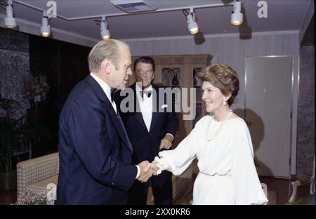 Gerald R. Ford, Nancy Reagan, Ronald Reagan – Gerald Ford e Nancy Reagan stringono la mano; Ronal Reagan in background; abbigliamento formale – viaggio in campagna in California; prima di salute alla cena presidenziale - Beverly Hills, California. 1976, 19 agosto Foto Stock