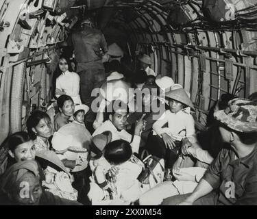 Sbalorditi dalla brutalità di un attacco dei Viet Cong al loro villaggio, i rifugiati di guerra del Vietnam viaggiano su un elicottero dell'Aeronautica militare in un'area sicura vicino a Saigon. Marzo 1966 Foto Stock