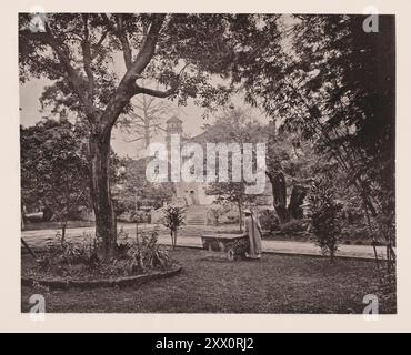 Foto d'epoca del consolare britannico Yamun a Canton (Guangzhou) con la Pagoda dei Fiori del Tempio dei sei alberi di Banyan sullo sfondo. Illustrazioni della Cina Qing, 1875 gli yamun, o residenze del governatore generale e di altri alti ufficiali della provincia, si trovano nel quartiere Tartar della città. L'area coperta da ciascuno di questi yamuns è considerevole, in quanto comprende, oltre all'abitazione privata del mandarino, i tribunali e gli uffici dei suoi dipartimenti nell'amministrazione. Il Consolato britannico è formato dalla metà posteriore dello yamun del generale tartaro. Un muro racchiude uno spazio Foto Stock